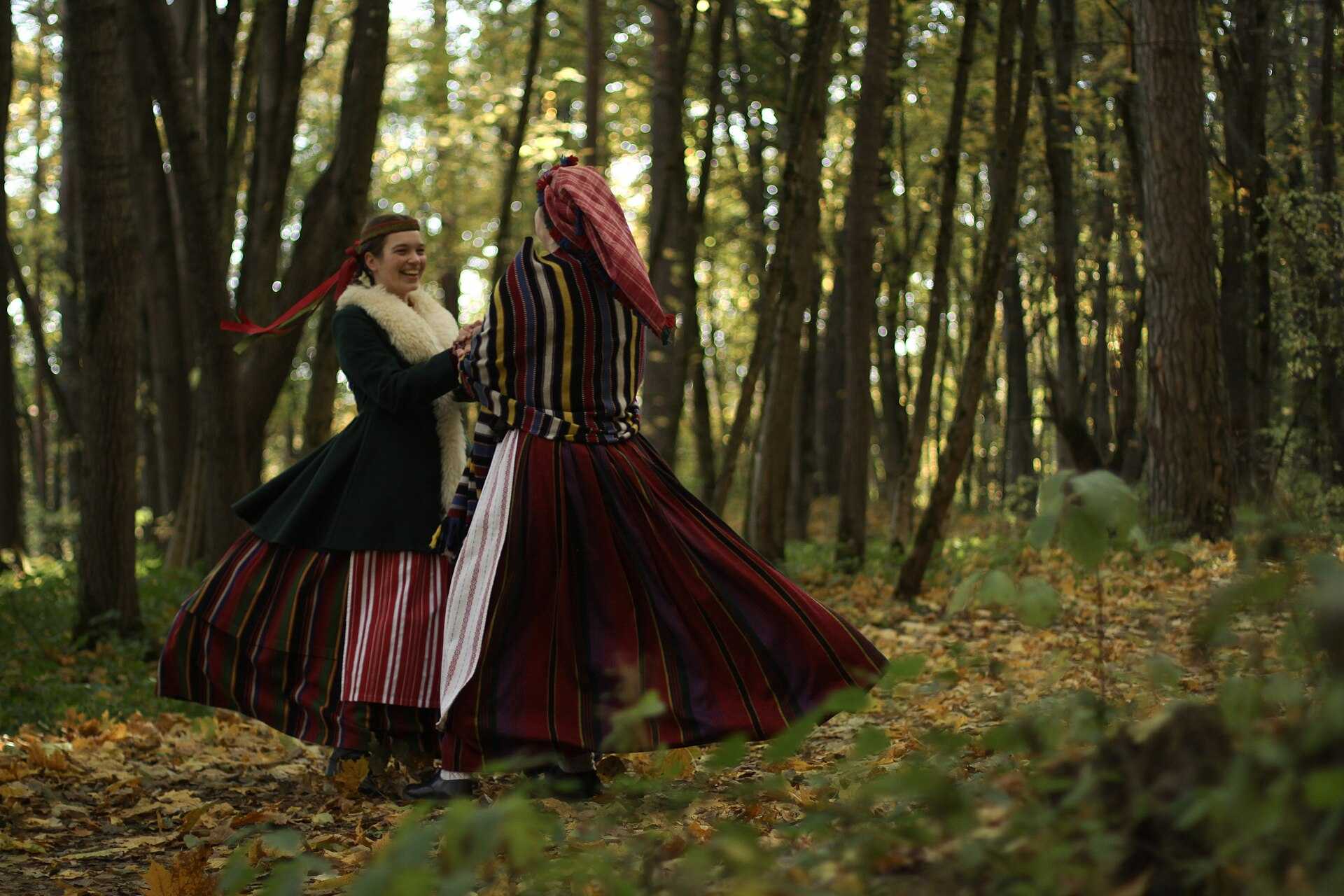 Girls dancing in colorful striped traditional Lithuanian costumes